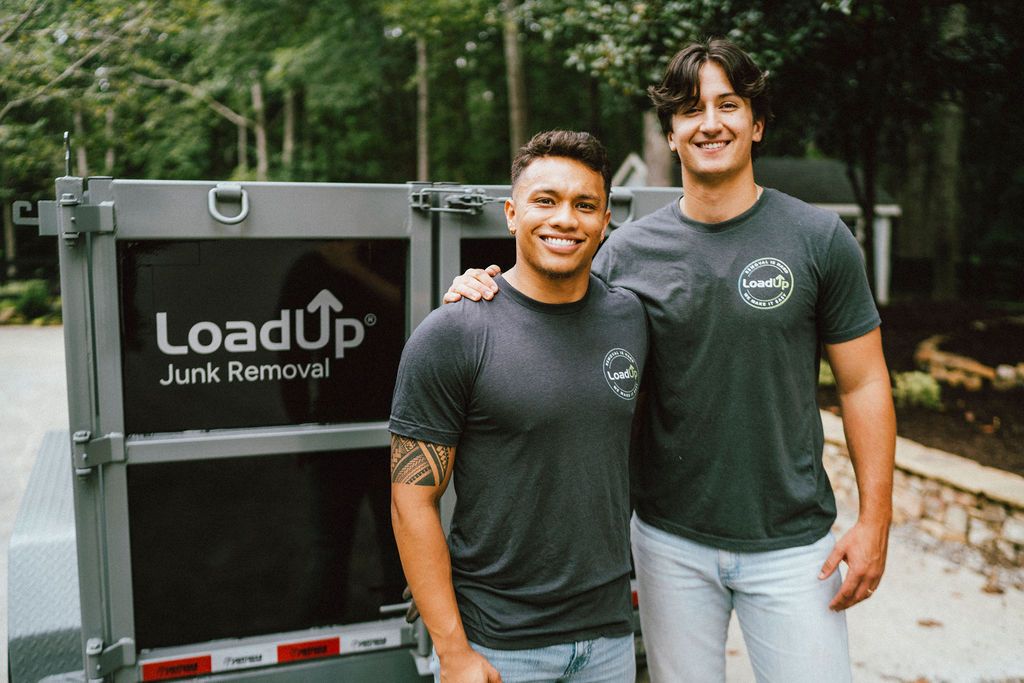 Two LoadUp Loaders standing beside a LoadUp junk removal trailer