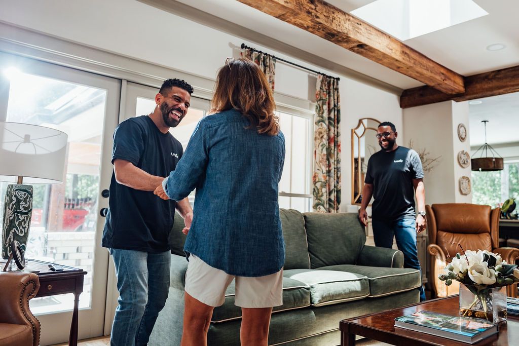 A LoadUp Loader shaking hands with a Montclair customer in her living room before the sofa pickup begins