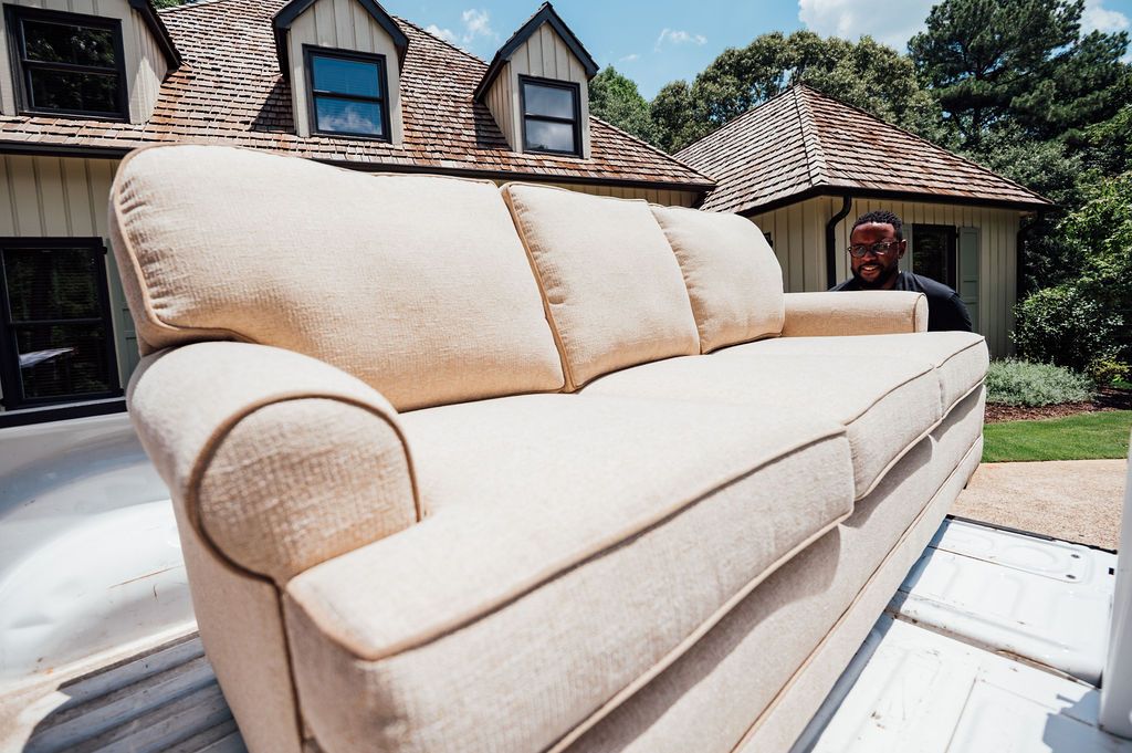 A cream three-seat sofa loaded onto a LoadUp truck bed outside a Montecito home