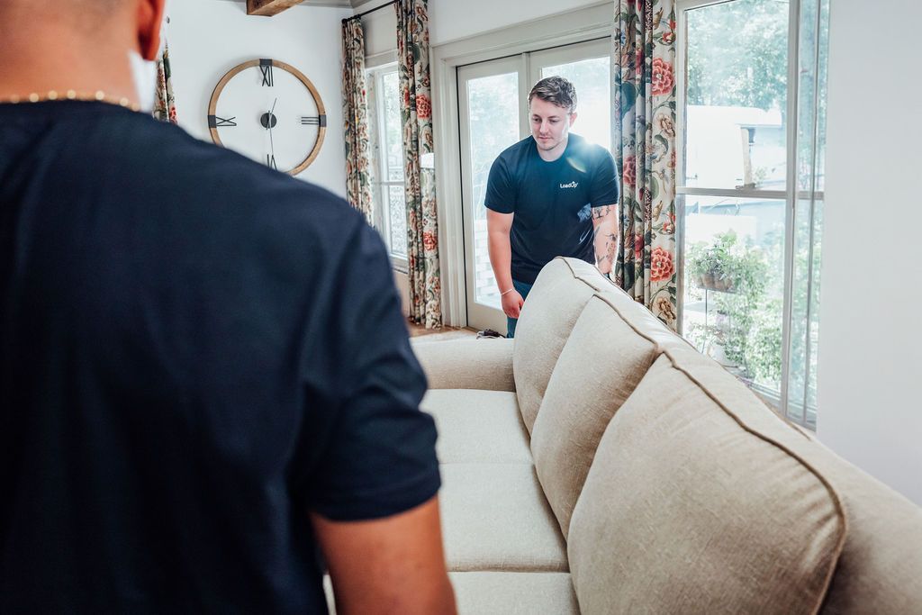 A LoadUp Loader positioning a cream sofa near the patio doors of a Montecito home